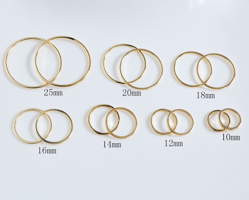 May include: Set of ten gold-toned metal jump rings in various sizes, ranging from 10mm to 25mm in diameter. The rings are arranged in two rows, with the smallest rings on the right and the largest rings on the left.