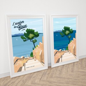 Peut inclure: Deux impressions encadrées d'une illustration colorée d'un escalier descendant vers une mer bleue avec un arbre vert sur le côté droit. Le texte "L'escalier des Baux" est en haut de l'impression.