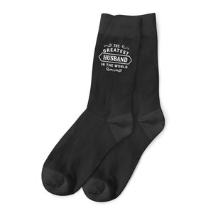 Peut inclure: Chaussettes noires avec un motif blanc qui dit "Le meilleur mari du monde".