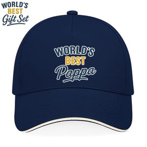 May include: A navy blue baseball cap with a white brim and the text "WORLD'S BEST PAPPA" in white and gold lettering. The words "WORLD'S BEST Gift Set" are also visible in white and blue.