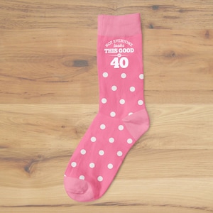 May include: Pink socks with white polka dots and the text "NOT EVERYONE looks THIS GOOD at 40".