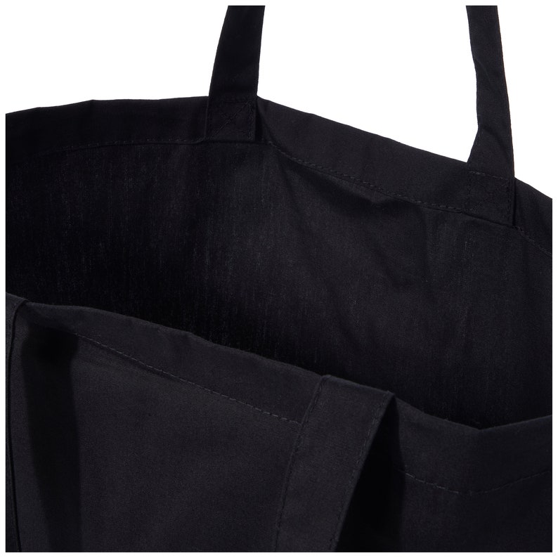 Puede incluir: Una bolsa de lona negra con dos asas. La bolsa est&aacute; vac&iacute;a y el interior es visible.