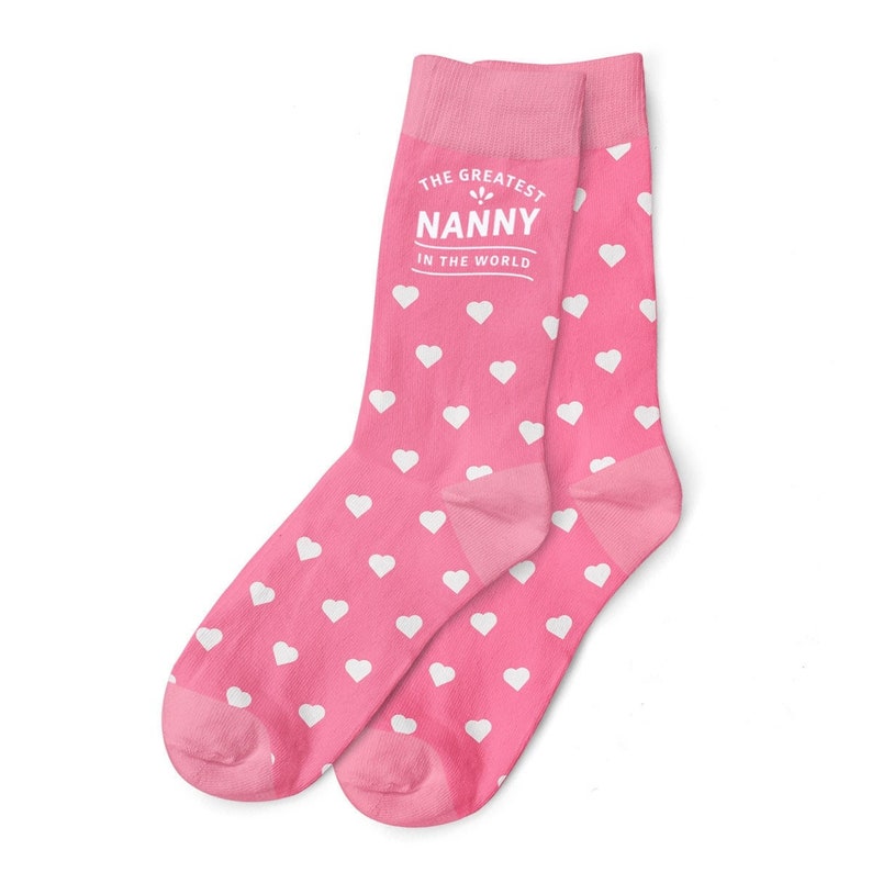 May include: Pink socks with white hearts and the text "The Greatest Nanny in the World".