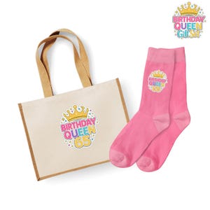 Pode incluir: Um conjunto de presentes com uma sacola de lona e meias rosa. A sacola tem uma alça marrom e um gráfico colorido "Birthday Queen 65". As meias também têm um gráfico correspondente. Um gráfico menor "Birthday Queen Gift Set" também é visível.