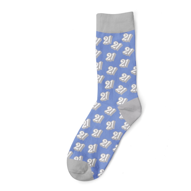 May include: A single sock with a light blue background and a repeating pattern of the number "21" in white with a gray shadow. The toe and heel are gray, and the cuff is also gray.