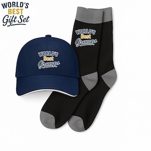 Puede incluir: Un juego de regalo que incluye una gorra de béisbol azul marino y calcetines negros. El texto "WORLD'S BEST Grumps" está escrito en blanco y azul. La gorra tiene un ribete blanco. Los calcetines tienen talones y dedos grises.