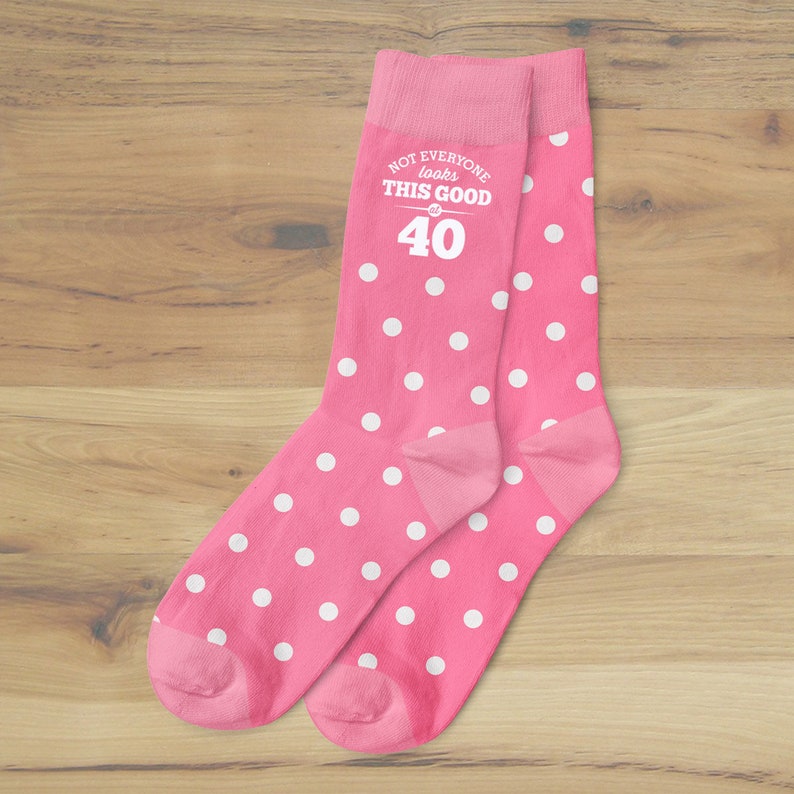 May include: Pink socks with white polka dots and the text "Not everyone looks this good at 40".