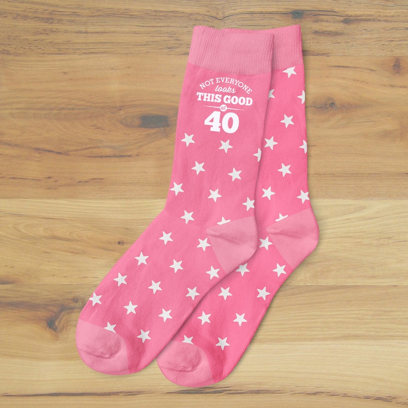 May include: Pink socks with white stars and the text "Not everyone looks this good at 40".