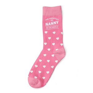 May include: Pink socks with a white heart pattern and the text "The Greatest Nanny in the World" printed on the top.
