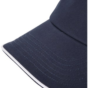 May include: A navy blue baseball cap with a white trim around the brim.