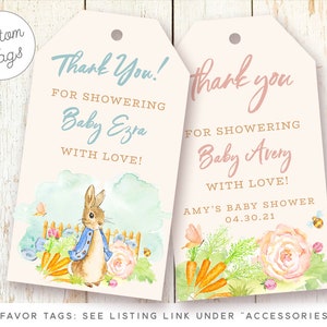 May include: Two pink and white baby shower favor tags with a watercolor illustration of a bunny rabbit and carrots. The text on the tags reads "Thank You! For Showering Baby Ezra With Love!" and "Thank You! For Showering Baby Avery With Love! Amy's Baby Shower 04.30.21".