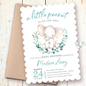 May include: A baby shower invitation with a cute cartoon elephant in a wreath of green leaves. The invitation says "a little peanut is on the way!" and includes the name "Madison Avery", the date "March 24", the time "2:30pm", the location "the avery residence", the address "245 morning glory lane, carmel", the RSVP number "425.243.9921", and the registry information "pottery barn kids".