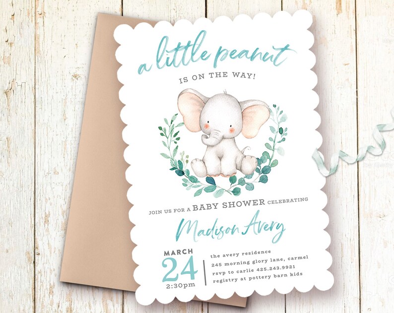 May include: A baby shower invitation with a cute cartoon elephant in a wreath of green leaves. The invitation says "a little peanut is on the way!" and includes the name "Madison Avery", the date "March 24", the time "2:30pm", the location "the avery residence", the address "245 morning glory lane, carmel", the RSVP number "425.243.9921", and the registry information "pottery barn kids".