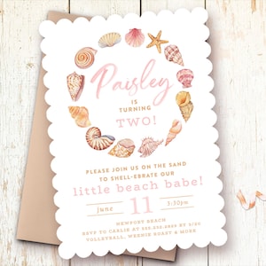 May include: A pink and white invitation with a seashell border. The text reads "Paisley is turning TWO!" and "Please join us on the sand to shell-ebrate our little beach babe!" The invitation also includes the date, time, and RSVP information.
