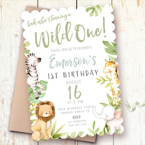 May include: A white invitation with green foliage and animal illustrations for a first birthday party. The text reads "Look who's turning a Wild One!" and "Emerson's 1st Birthday August 16".