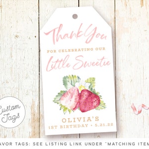 May include: Pink and white favor tag with a watercolor illustration of strawberries. The tag says "Thank You for celebrating our Little Sweetie Olivia's 1st Birthday 5.21.22".