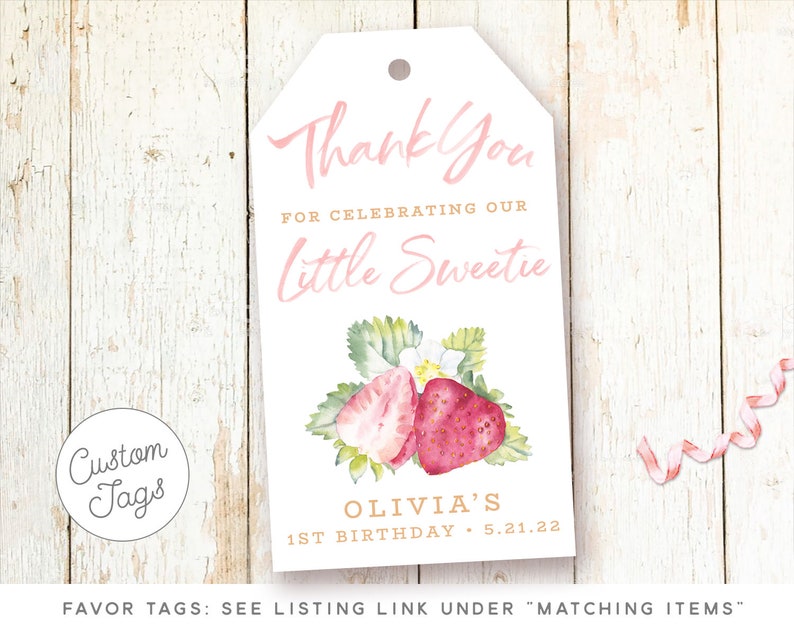 May include: Pink and white favor tag with a watercolor illustration of strawberries. The tag says "Thank You for celebrating our Little Sweetie Olivia's 1st Birthday 5.21.22".