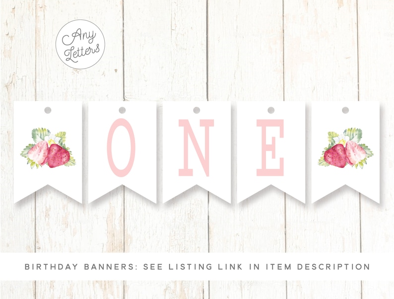 May include: White banner with pink letters spelling "ONE" and strawberry illustrations. The banner is for a first birthday party.
