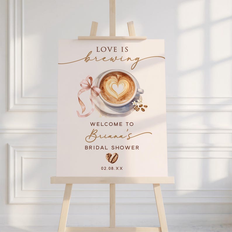 May include: A cream-colored sign on a wooden easel with the words "Love is Brewing" in elegant script. A watercolor image of a coffee cup with a heart-shaped design is featured. The sign welcomes guests to Briana's Bridal Shower.