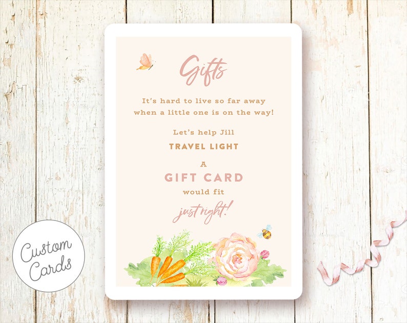 May include: A pink and white card with a floral design and the text "Gifts It's hard to live so far away when a little one is on the way! Let's help Jill TRAVEL LIGHT A GIFT CARD would fit justright!"