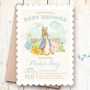 May include: A white baby shower invitation with a scalloped border. The invitation features a watercolor illustration of Peter Rabbit in a garden setting. The text reads "Join us for a Baby Shower Honoring Madison Avery June 22 2:30pm the potter residence 245 morning glory lane, carmel rsvp to carlie 435.243.9931 registry at pottery barn kids"