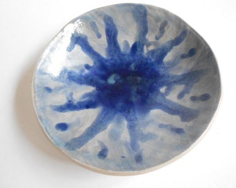 Handmade blue white pottery bowl with organic shape and textured underside