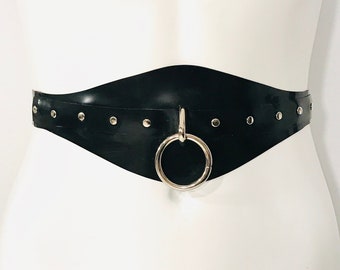 May include: A black leather belt with silver studs and a large silver ring. The belt is on a white mannequin.