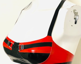May include: A red and black striped latex bra with silver buckles and adjustable straps.