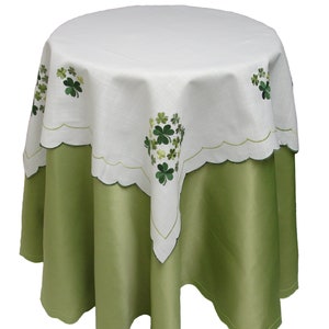 May include: A white tablecloth with green shamrock embroidery, featuring a scalloped edge and a green satin drop.