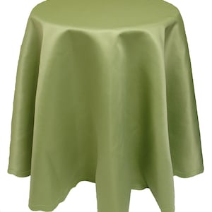 May include: A sage green round tablecloth with a smooth satin finish. The tablecloth has a simple design and a stitched hem.