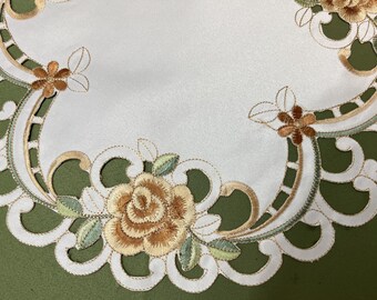 花の刺繍が施された円形のテーブルセンターのカットワーク装飾