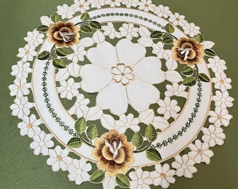 花の刺繍が施された円形のテーブルセンターのカットワーク装飾