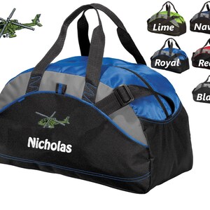 May include: A blue and black duffel bag with a helicopter and the name "Nicholas" embroidered on it. The bag has a top handle and a shoulder strap. The bag is available in a variety of colors, including lime, navy, royal, red, and black.
