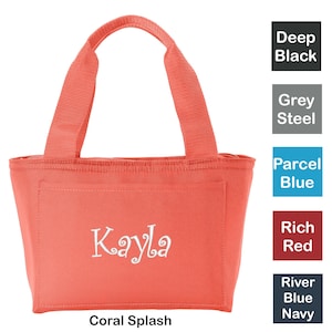Puede incluir: Bolsa de almuerzo aislada de color coral con una cremallera blanca y dos asas de coral. La bolsa tiene un nombre bordado en blanco "Kayla" en la parte delantera.
