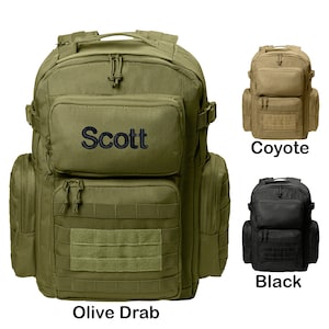 May include: A green, black, and coyote tactical backpack with multiple pockets and straps. The backpack has a name tag that says "Scott".