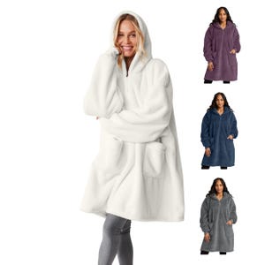 Puede incluir: Una manta con capucha blanca con cremallera frontal y dos bolsillos delanteros. La modelo lleva leggings grises. Se muestran mantas adicionales en morado, azul marino y gris.