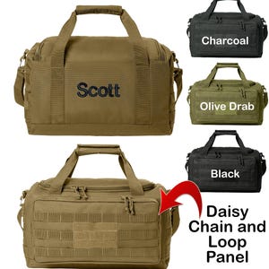 May include: A tan canvas duffel bag with a black embroidered name "Scott". The bag has a daisy chain and loop panel on the front. The bag is shown next to three other bags in charcoal, olive drab, and black.
