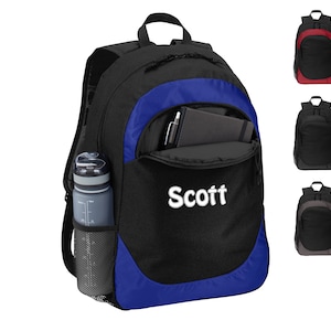 May include: A black backpack with a blue trim and a mesh side pocket for a water bottle. The backpack has a zippered front pocket with a name tag that says "Scott".