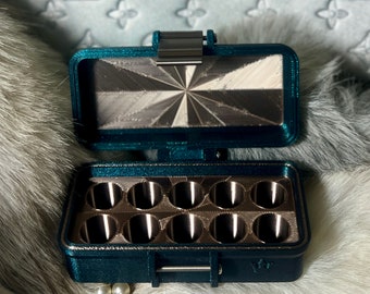May include: A teal blue, rectangular, hinged storage case with a silver latch. The case has 10 round, silver-colored compartments inside.