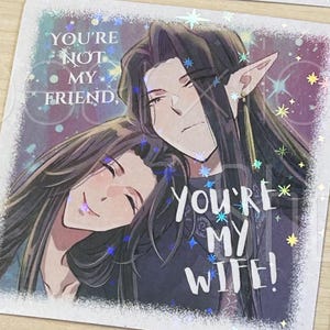May include: Rectangular sticker featuring an anime-style illustration of two figures embracing. One figure has long black hair and pointed ears. Text on the sticker reads "You're not my friend, you're my wife!" with a holographic effect.