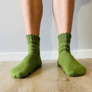 Puede incluir: Un par de calcetines de corte tobillero en un color verde lima sólido y vibrante. Estos calcetines presentan una textura de punto fino en todo el pie y la pierna, terminados con un puño acanalado en la parte superior para un ajuste ceñido.