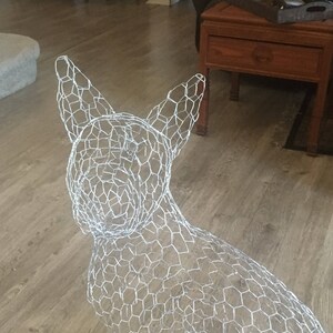 May include: A wire mesh dog sculpture, a popular craft project for home decor. The sculpture is made of silver wire and is shaped like a dog sitting up.