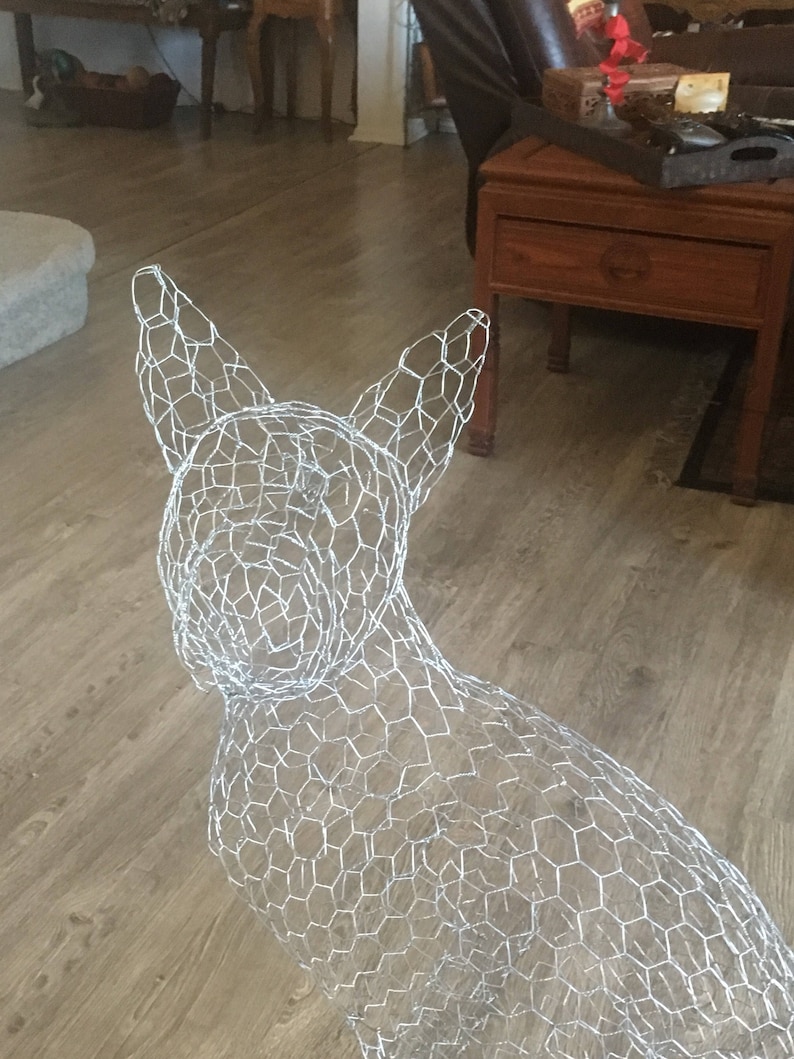 May include: A wire mesh dog sculpture, a popular craft project for home decor. The sculpture is made of silver wire and is shaped like a dog sitting up.