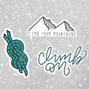 May include: Three stickers with a mountain range, a rope knot, and the words "climb on" in a handwritten style. The mountain range sticker has the text "Climb your mountains" below it.
