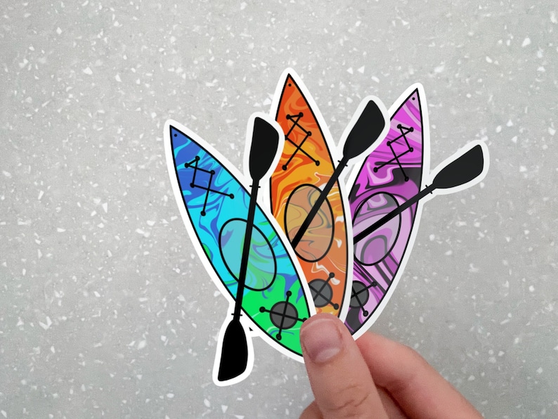 May include: Four colorful kayak stickers with black paddles. The kayaks are in shades of blue, green, orange, and purple with a swirl pattern.