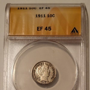 May include: A 1911 United States 10 cent coin graded in a clear plastic holder. The coin is graded EF 45 by ANACS.