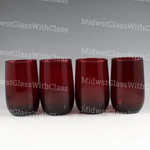 May include: Four stemless wine glasses in a deep red hue. The glasses have a rounded shape and a smooth, glossy finish. The text "MidwestGlassWithClass" is repeated across the image.
