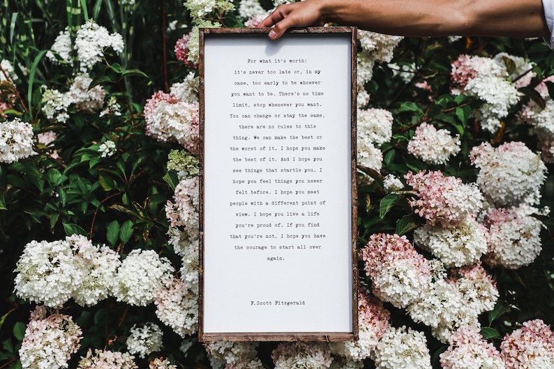 May include: A framed print with a white background and black text. The text is a quote by F. Scott Fitzgerald that reads: "For what it's worth, it's never too late or, in my case, too early to be whoever you want to be. There's no time limit, stop whenever you want. You can change or stay the same. There are no rules to this thing. We can make the best or the worst of it. I hope you make the best of it. And I hope you see things that startle you. I hope you feel things you never felt before. I hope you meet people with a different point of view. I hope you live a life you're proud of. If you find that you're not, I hope you have the courage to start all over again."
