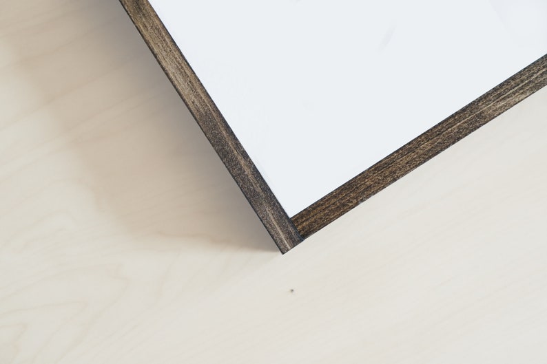 May include: Close-up of the corner of a wood frame with a dark brown stain. The frame is made of wood and has a smooth finish.