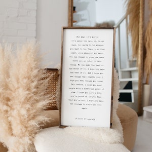 May include: A framed print with a white background and black text. The text is a quote by F. Scott Fitzgerald about the importance of making the best of life and having the courage to start over. The quote is printed in a typewriter font.